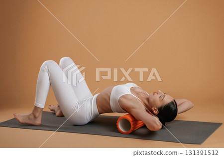 Exercises on yoga mat. Beautiful fitness woman is in the studio Exercises on yoga mat. Beautiful fitness woman is in the studio 131391512