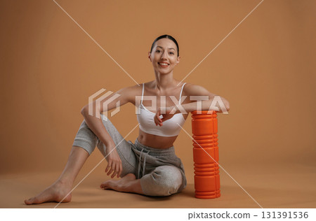 On the floor, sitting. Beautiful fitness woman is in the studio 131391536
