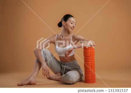 On the floor, sitting. Beautiful fitness woman is in the studio 131391537