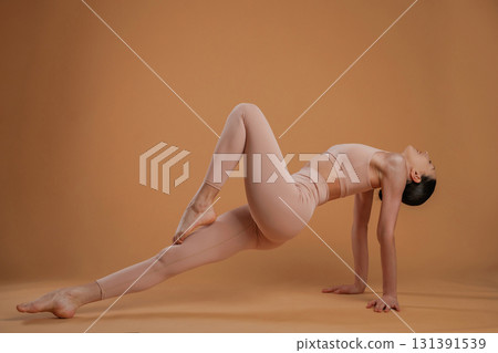 Amazing stretch. Beautiful fitness woman is in the studio Amazing stretch. Beautiful fitness woman is in the studio 131391539