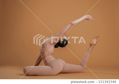 Amazing stretch. Beautiful fitness woman is in the studio Amazing stretch. Beautiful fitness woman is in the studio 131391540