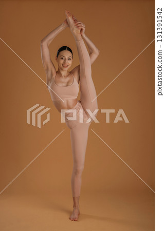 Leg is high up, good stretching. Beautiful fitness woman is in the studio 131391542