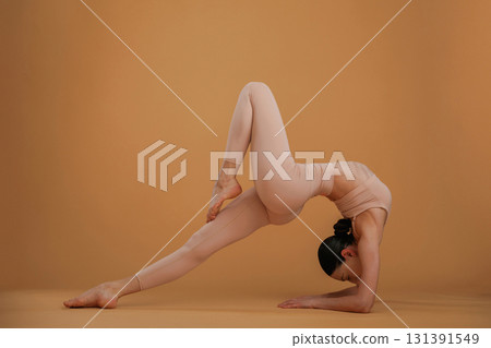 Flexible exercises. Beautiful fitness woman is in the studio Flexible exercises. Beautiful fitness woman is in the studio 131391549