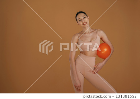 With red ball. Beautiful fitness woman is in the studio With red ball. Beautiful fitness woman is in the studio 131391552