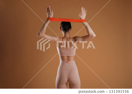 Cloth for stretching hands. Beautiful fitness woman is in the studio 131391556