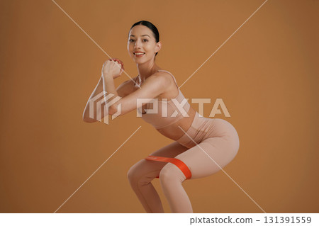 Doing squats. Beautiful fitness woman is in the studio 131391559