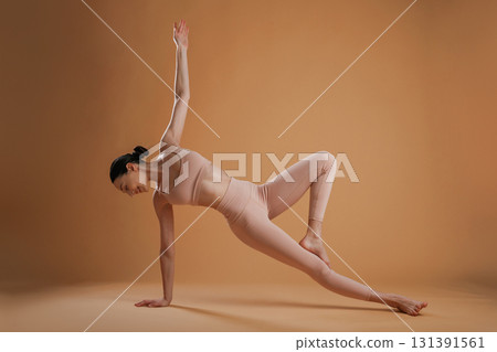 Flexible exercises. Beautiful fitness woman is in the studio Flexible exercises. Beautiful fitness woman is in the studio 131391561