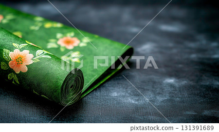 Green textured background with floral design paper rolled on dark surface 131391689
