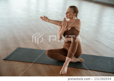 Front view. Warm up exercises. Fitness woman in sportswear is indoors Front view. Warm up exercises. Fitness woman in sportswear is indoors 131392034
