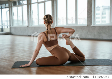 Leg stretching. Fitness woman in sportswear is indoors 131392047