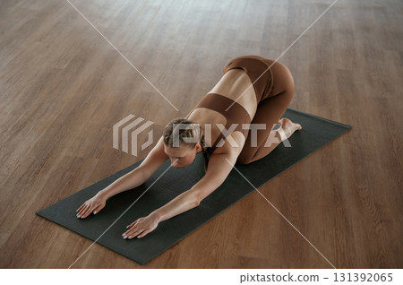 Spine exercise. Fitness woman in sportswear is indoors 131392065