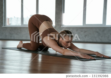 Spine exercise. Fitness woman in sportswear is indoors Spine exercise. Fitness woman in sportswear is indoors 131392066