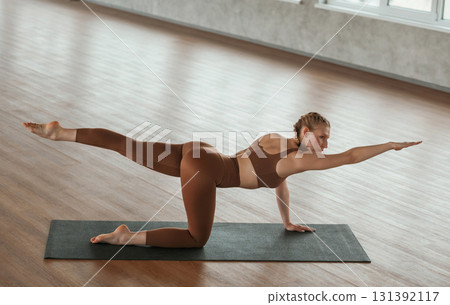 Flexible body, doing stretching. Fitness woman in sportswear is indoors 131392117
