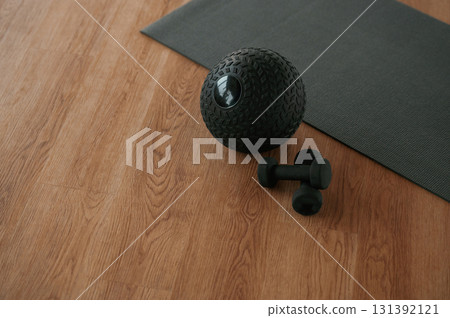 Fitness ball and dumbbells on the floor with yoga mat 131392121
