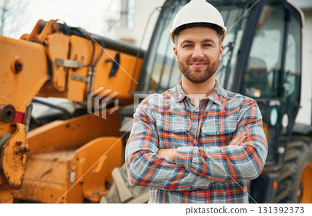 In white hard hat. Man is with tractor. Agricultural worker 131392373