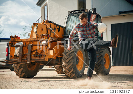 Mad, angry emotion. Man is with tractor. Agricultural worker Mad, angry emotion. Man is with tractor. Agricultural worker 131392387