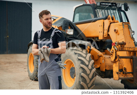 Cleaning the hands after job is done, mechanic. Man is with tractor. Agricultural worker 131392406