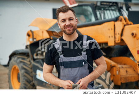 Job well done, with cloth to clean the hands. Man is with tractor. Agricultural worker 131392407