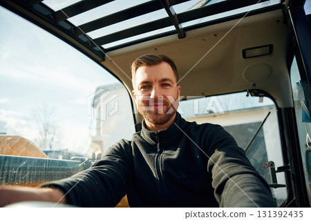 By the steering wheel. Man is with tractor. Agricultural worker By the steering wheel. Man is with tractor. Agricultural worker 131392435