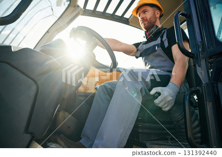 Sitting in the vehicle. Man is with tractor. Agricultural worker Sitting in the vehicle. Man is with tractor. Agricultural worker 131392440