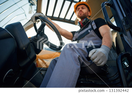 Sitting in the vehicle. Man is with tractor. Agricultural worker Sitting in the vehicle. Man is with tractor. Agricultural worker 131392442