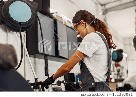 A Highly Skilled Female Mechanic Working in a Modern and Innovative Workshop Environment A Highly Skilled Female Mechanic Working in a Modern and Innovative Workshop Environment 131393081