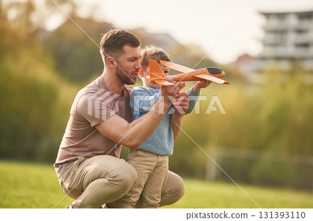 Freedom, playing with toy plane. Happy father with son are having fun on the field at summertime Freedom, playing with toy plane. Happy father with son are having fun on the field at summertime 131393110