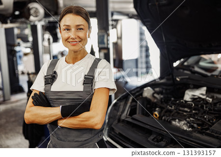A female mechanic proudly works in an auto shop, symbolizing confidence and empowerment 131393157