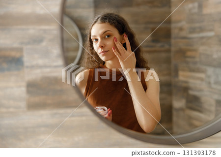 SelfCare Ritual Applying Cream in Front of the Mirror for Enhancing Your Beauty Routine 131393178