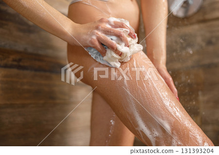 A Woman Showering with Soap and a Sponge in a Beautiful Rustic Bathroom Environment A Woman Showering with Soap and a Sponge in a Beautiful Rustic Bathroom Environment 131393204