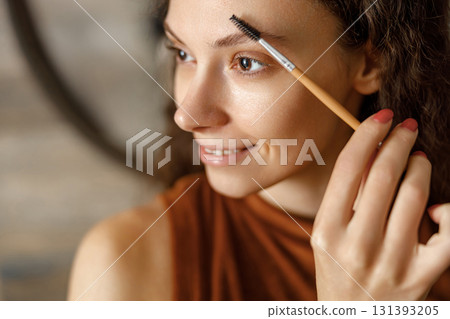 A Woman Carefully Applying Eyebrow Makeup in Beautiful Natural Light for a Radiant Look A Woman Carefully Applying Eyebrow Makeup in Beautiful Natural Light for a Radiant Look 131393205