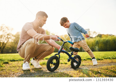 Bicycle, having fun. Happy father with son are on the field at summertime Bicycle, having fun. Happy father with son are on the field at summertime 131393430