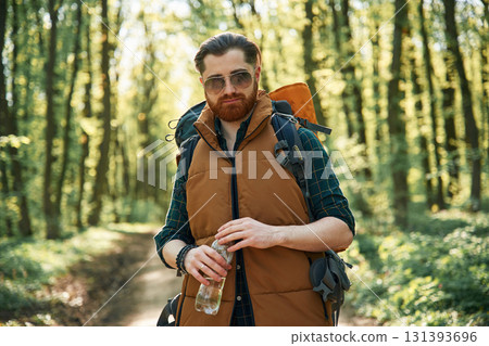 Enjoying warm weather and nature. Bearded man is in the forest at daytime Enjoying warm weather and nature. Bearded man is in the forest at daytime 131393696