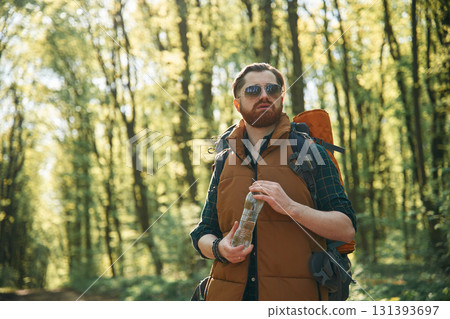 Enjoying warm weather and nature. Bearded man is in the forest at daytime Enjoying warm weather and nature. Bearded man is in the forest at daytime 131393697
