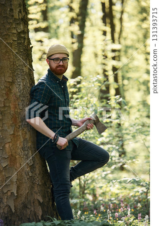 Woodcutter is standing. Bearded man is in the forest at daytime 131393715