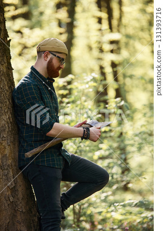 Woodcutter is standing. Bearded man is in the forest at daytime 131393716