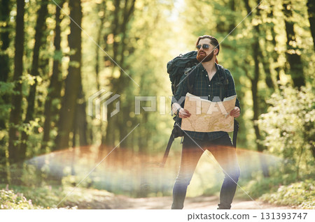 Beautiful lens effect. Bearded man is in the forest at daytime Beautiful lens effect. Bearded man is in the forest at daytime 131393747