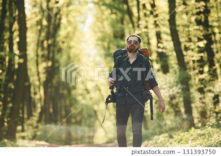 On the pathway with binoculars. Bearded man is in the forest at daytime On the pathway with binoculars. Bearded man is in the forest at daytime 131393750