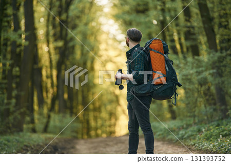 On the pathway with binoculars. Bearded man is in the forest at daytime On the pathway with binoculars. Bearded man is in the forest at daytime 131393752