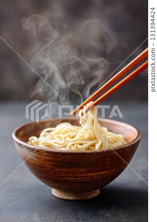 Soba noodles in rustic bowl with steam rising, captured in minimalist style, showcasing the delicate texture and warmth of this traditional dish with copy space 131394424