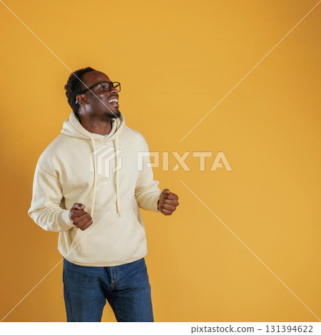 In glasses, looks to the copy space. Black guy is against yellow background 131394622