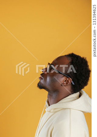 In glasses, looks to the copy space. Black guy is against yellow background 131394625