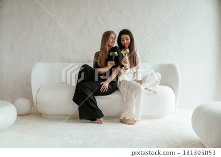 Event, with drinks, celebrating. Two happy young female best friends are indoors Event, with drinks, celebrating. Two happy young female best friends are indoors 131395051