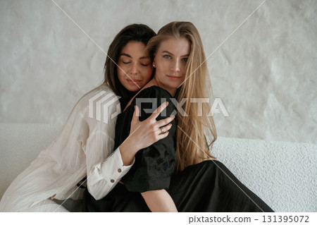 Moment of appreciation. Embracing the woman. Two happy young female best friends are indoors Moment of appreciation. Embracing the woman. Two happy young female best friends are indoors 131395072