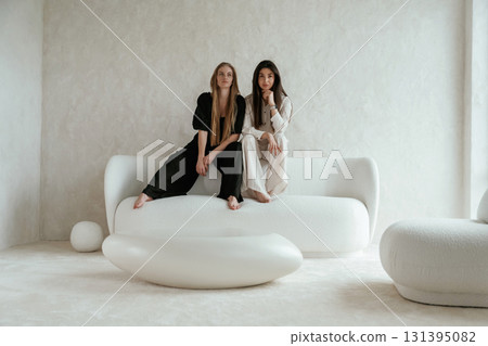 Resting, sitting together. Two happy young female best friends are indoors 131395082