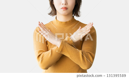 A woman with a troubled expression making a cross pose with her hands A woman with a troubled expression making a cross pose with her hands 131395589