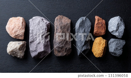 Rock samples show diverse textures and colors on a dark backdrop, emphasizing geological variety 131396058