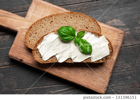 Butter and bread on wooden board 131396151