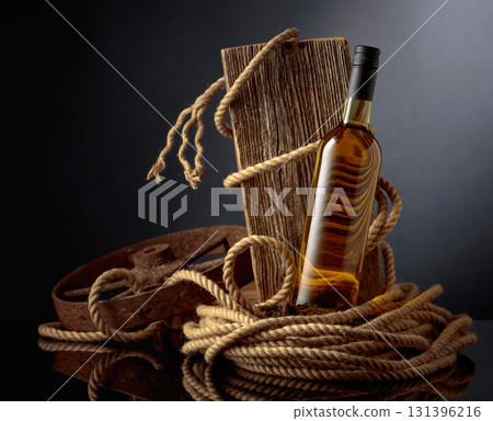 Bottle of  white wine with old weathered board and hemp rope. 131396216