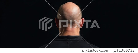 Bald man from behind posing on black background with copy space 131396732